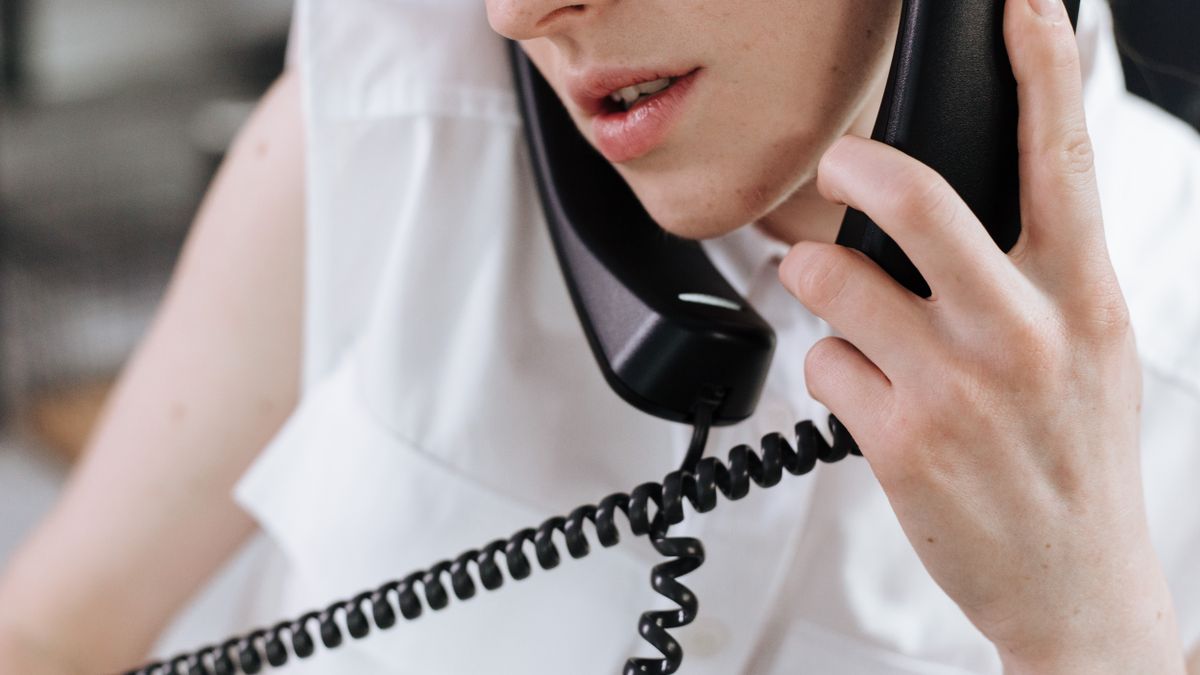 Close-up of a woman talking on a phone in an office setting.