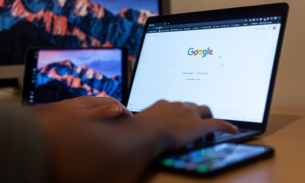 Hands typing on a laptop with Google on screen, in a remote work setup in Milan, Italy.