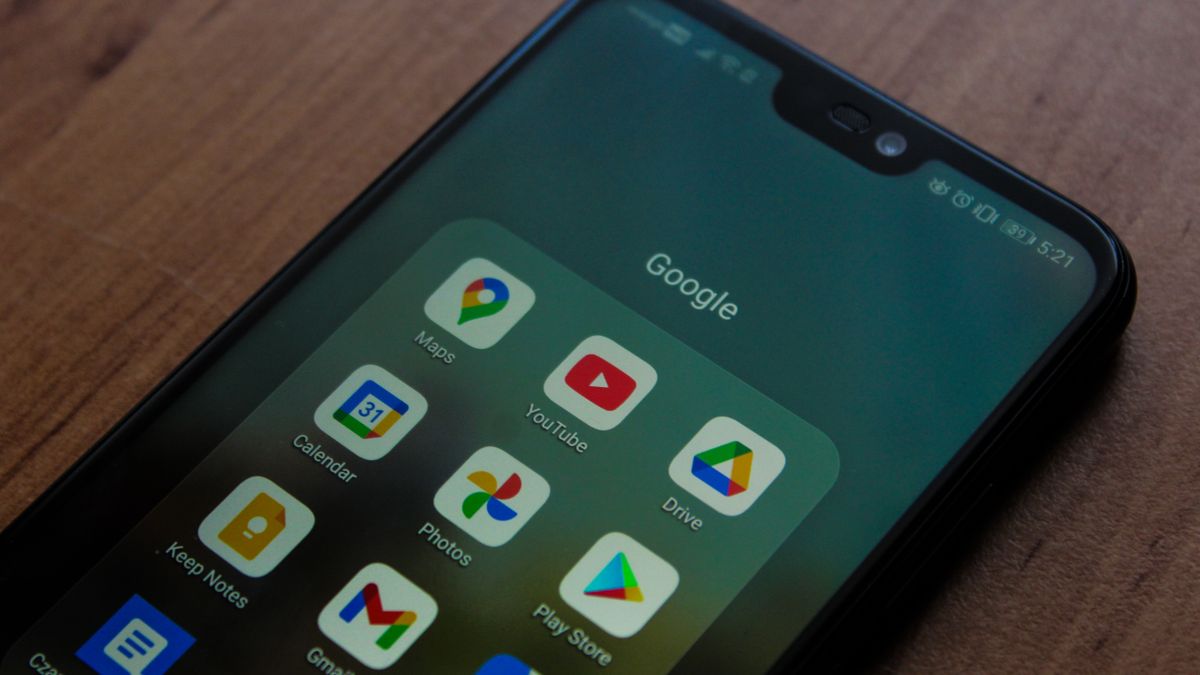 Close-up of a smartphone showing various Google apps on its screen.
